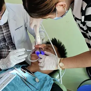 Dentist and assistant performing a braces procedure on a patient in Kalika Dental Care