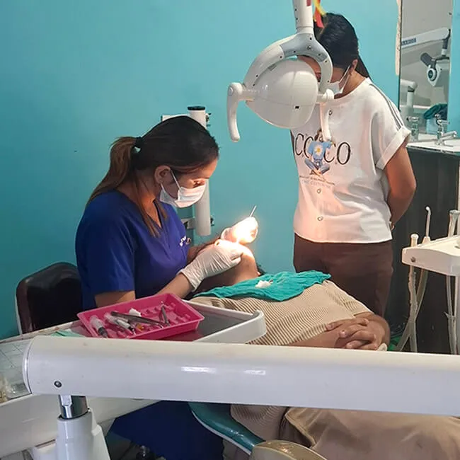 Dentist and assistant providing dental care in fully equipped treatment room at Kalika Dental Care